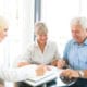 an elderly couple talking to a life insurance agent