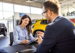 woman is discussing embedded auto insurance with salesman