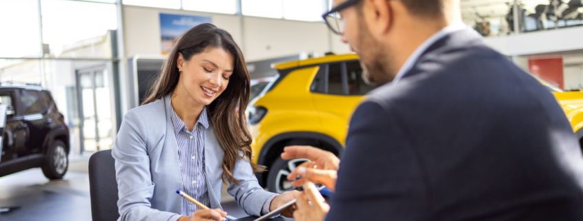 woman is discussing embedded auto insurance with salesman