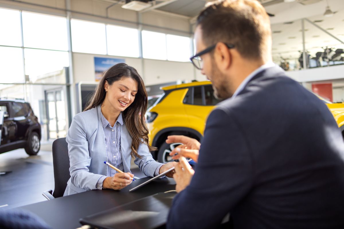 woman is discussing embedded auto insurance with salesman