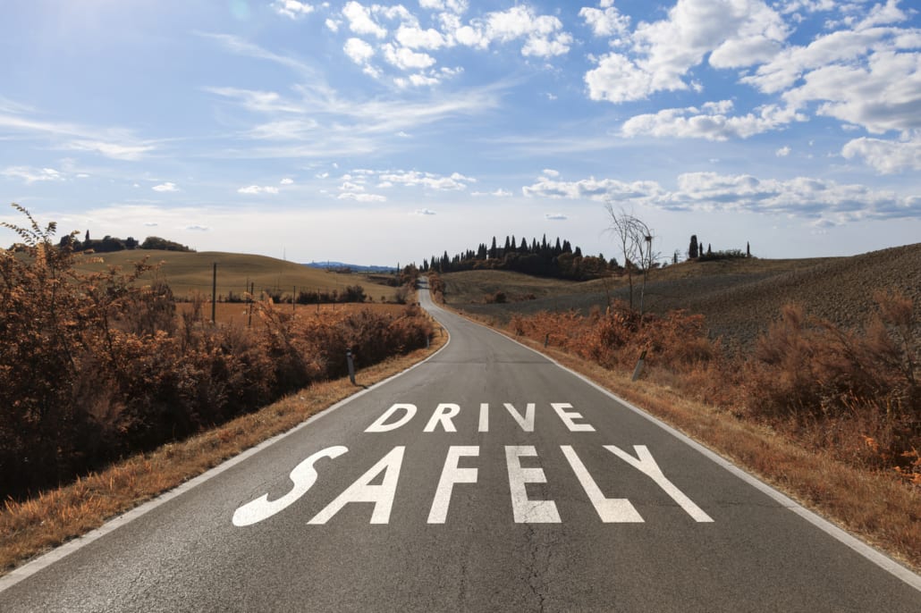 a long road with "drive safely" written on it