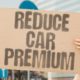 person holding a board asking how to lower your car insurance premium