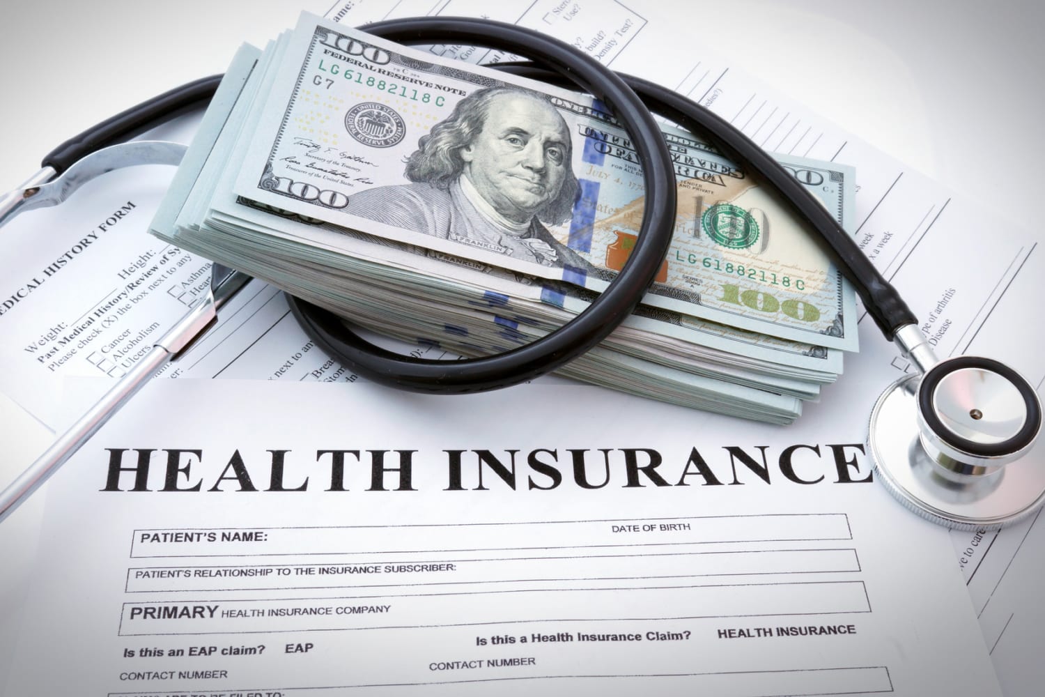 Health insurance form with dollars and stethoscope