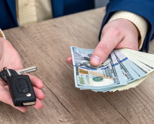 Businessman holding car key and money