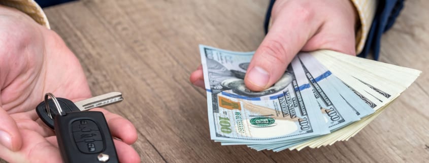 Businessman holding car key and money